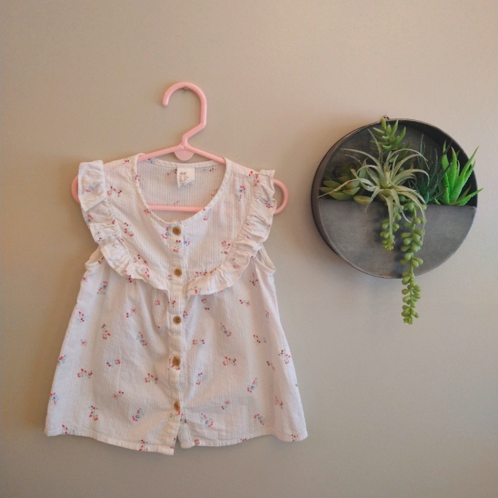 H&M white sleeveless button up blouse with ruffle detail and floral print
